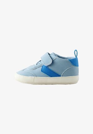 Zapatilla deportiva azul claro con una tira de velcro, que presenta un acento azul más oscuro, textura suave y una suela de goma blanca.