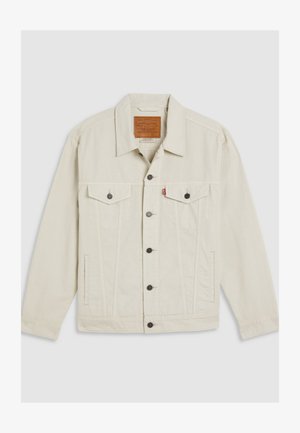 Lys beige denimjakke med krage, knappelukking, to brystlommer og kontrasterende mørke knapper. Har vertikale søm detaljer.