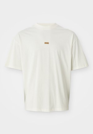 Hvid kortærmet T-shirt lavet af blød bomuld, med et lille brunt "HUGO" mærke centreret på brystet. Løs pasform med rund halsudskæring.