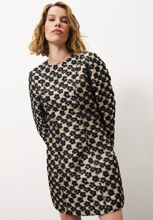 Leopardenmusterkleid mit beiger Grundfarbe und schwarzen Flecken, langen Ärmeln, Rundhalsausschnitt und figurbetonter Silhouette. Strukturierter Stoff mit Nahtdetails.