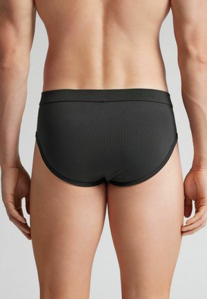 Maillots de bain pour hommes noirs, avec une ceinture élastique lisse et une coupe ajustée. Le tissu semble léger et extensible.
