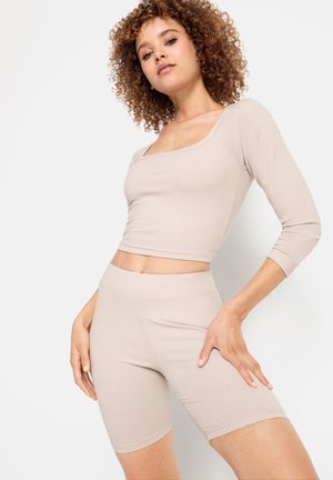Beige ribbed crop top with square neckline and three-quarter sleeves, paired with matching high-waisted shorts. Smooth texture and fitted design.