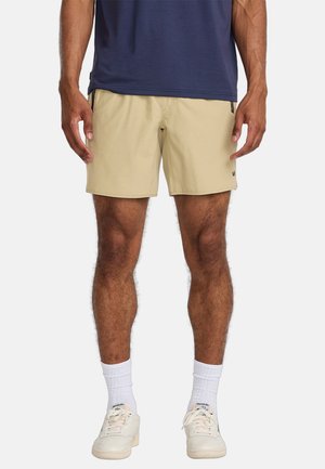 Beige shorts made of lightweight fabric with a relaxed fit, featuring side pockets and a subtle logo on the left leg.
