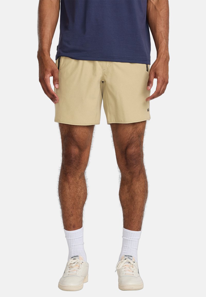 Pantalones cortos beige hechos de una tela ligera con un corte relajado, que cuentan con bolsillos laterales y un sutil logo en la pierna izquierda.