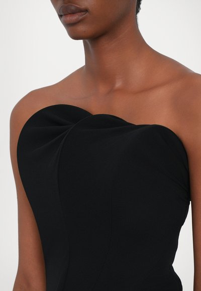 Black strapless dress featuring a fitted bodice with a sculpted design and smooth texture, highlighting gentle draping details.