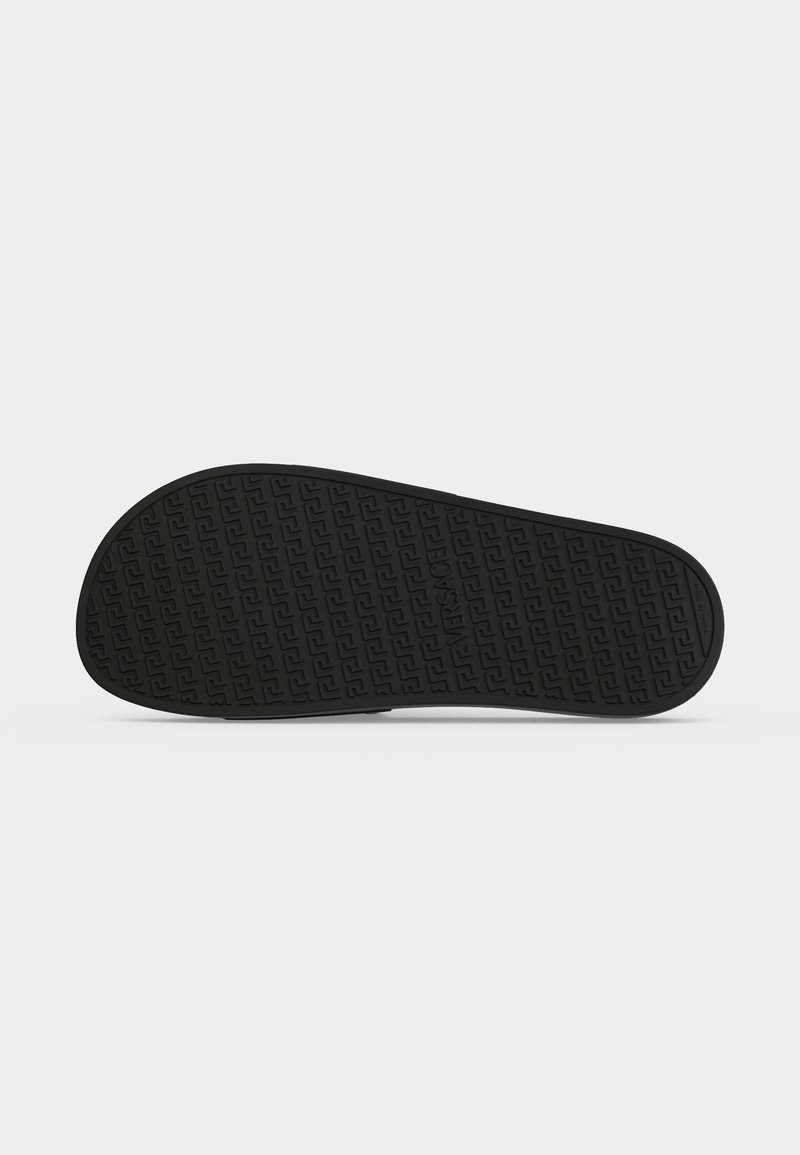 Black rubber shoe sole with patterned tread and embossed brand name on a plain light background.