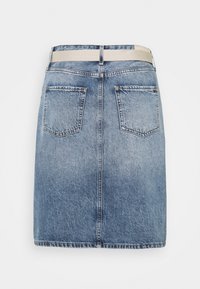 Vaaleansininen farkkhame suoranleikkauksella, kahdella takataskulla ja vaaleankermanvärisellä vyötäröresorilla, jossa on Tommy Hilfiger -logo.