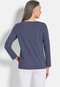 Gestreiftes langärmliges Shirt in Marineblau und Weiß mit einem Bootsausschnitt, aus weichem Stoff gefertigt, bietet eine lockere Passform und einen geraden Saum.