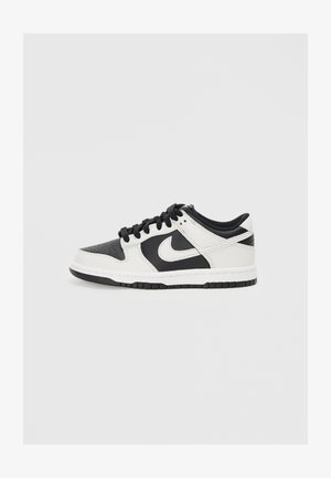 Fekete-fehér Nike sportcipő sima bőr felsőrésszel, perforált orral és fekete fűzőkkel. Gumitalpa van, amely texturált tapadással rendelkezik.