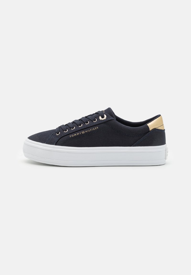 Marineblaue Leinen-Sneaker mit weißer Gummisohle, goldenen Akzenten an der Ferse und runder Zehenpartie. Verfügt über ein Schnürdesign mit sechs Metallösen.