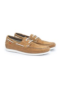 Scarpe da barca in camoscio marrone con suole in gomma bianca, dotate di occhielli in argento, dettagli di cucitura e un accento rosso di lato.