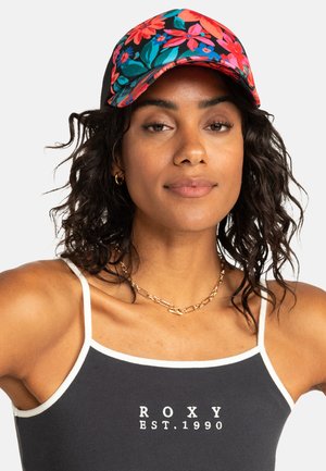 Schwarze Kappe mit floralem Muster, das rosa und türkisfarbene Blumen zeigt. Verstellbarer Riemen hinten, kombiniert mit einem schwarzen Tanktop, das "ROXY EST.1990." zeigt.