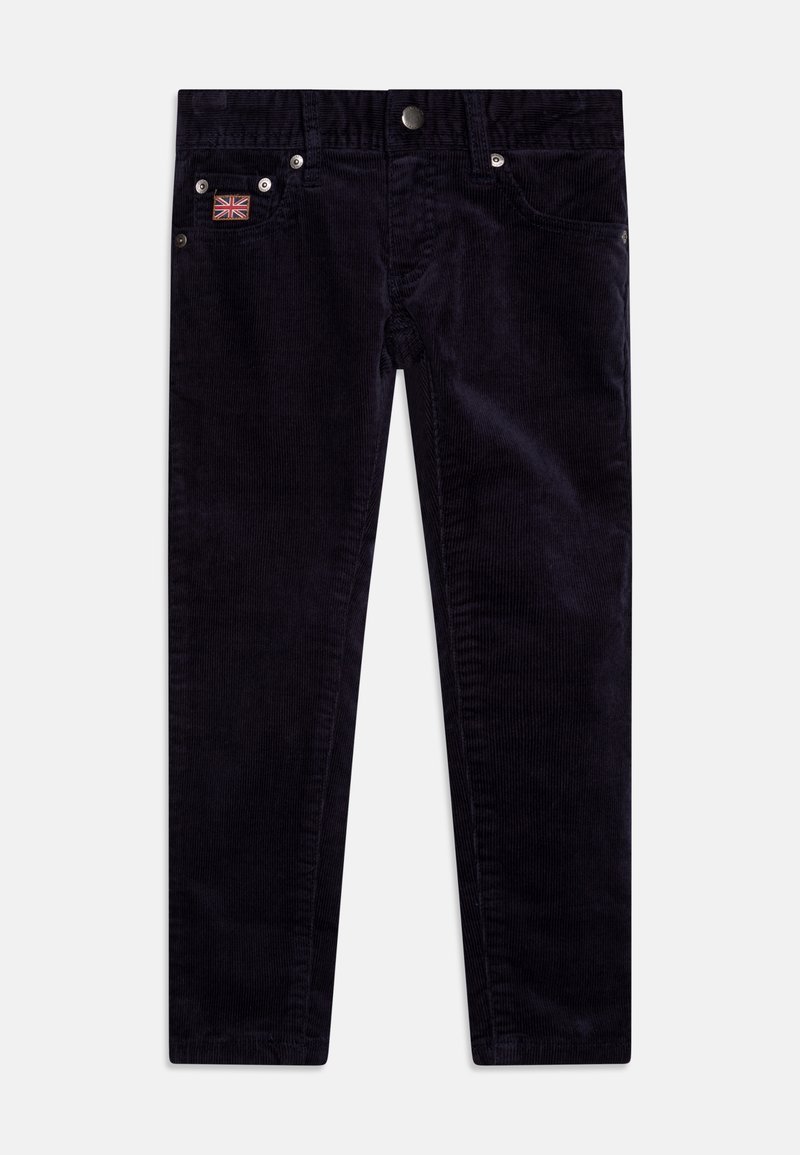 Pantalon en velours côtelé bleu marine avec poches avant, fermeture par bouton métallique et un petit patch drapeau Union Jack sur la poche droite.