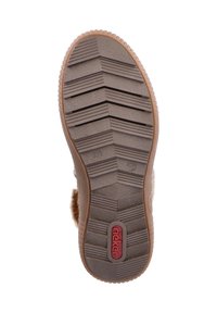 Semelle en caoutchouc marron avec un motif en chevrons pour une adhérence, présentant un logo rouge. Surface texturée avec des rainures verticales et des accents surélevés.