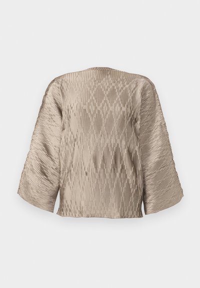 Beige pleated blouse with a boxy silhouette, wide sleeves, and textured ribbing pattern throughout. Smooth fabric with sheen.