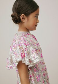 Sidabrinė sequin suknelė su gėlių raštais, turinti trumpas, raukšlėtas rankoves ir apvalų iškirpimą, atspindinti šviesą blizgiu paviršiumi.