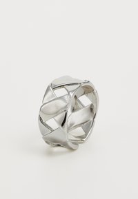Sølvmetallring med et intrikat geometrisk design, med utskårne mønstre og en polert overflate. Rund, med glatte kanter.