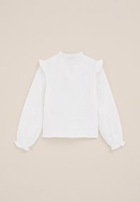 Weißes Langarmbluse aus strukturiertem Stoff mit gerüschten Schultern und Manschetten sowie einem hohen Ausschnitt, vor einem schlichten beigen Hintergrund.