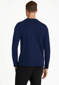 Langärmliges navy T-Shirt aus weichem Baumwollmaterial mit einem einfachen Rundhalsausschnitt und einer lässigen Passform, das eine dezente Textur aufweist.