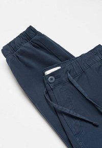 Marinblå byxor med elastisk midja, dragsko och knappdetalj. Slät textur med minimalistisk design och inga synliga mönster.