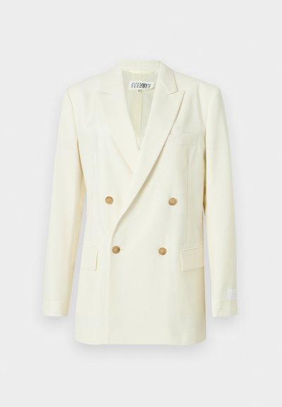 Lys cremefarvet dobbeltradet blazer i glat stof. Har guldfarvede knapper, hakkede revers og en enkelt brystlomme.