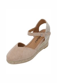 Scarpa con tacco a zeppa in suede beige con cinturino alla caviglia, punta aperta e suola avvolta in juta. Presenta una texture morbida e un design classico ideale per un look casual.