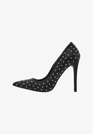 Zwarte pump met spitse neus en een stiletto-hak, versierd met gelijkmatig verspreide gouden studs op de bovenkant voor extra detail. Glad textuur.