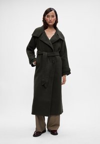 Casaco longo em mistura de lã verde escuro, com um colarinho largo, fecho de botão e cinto. Apresenta um corte descontraído e mangas largas.