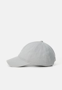 Căciulă de baseball gri deschis, din material textil, văzută din lateral, cu cusături vizibile și un bor conformat, pe un fundal alb.