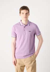 Lavanda polo majica s kratkim rukavima, s kontrastnim crnim i bijelim ovratnikom, te izvezenom oznakom "BOSS" na lijevoj strani grudi.