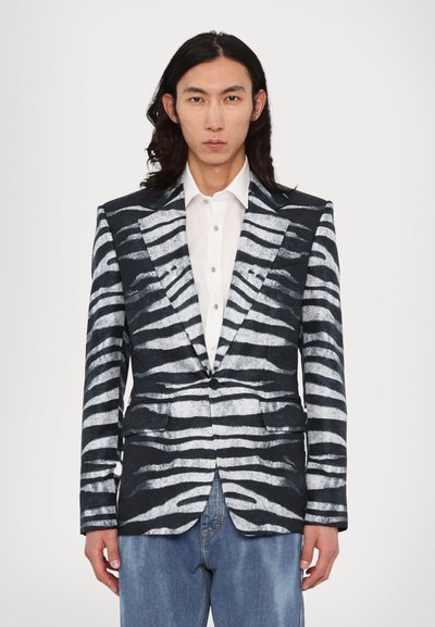 Sort-hvidt zebra-stribet blazer i en struktureret design, der har spidse revers, en enkelt knaplukning og to forlommer.