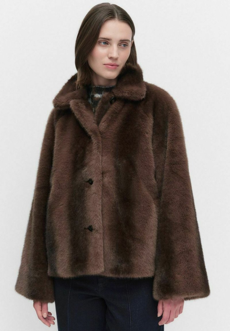 Brązowy płaszcz z sztucznego futra z szerokim kołnierzem, dwiema zapięciami na guziki i luźnymi rękawami. Miękka tekstura i gruby materiał.