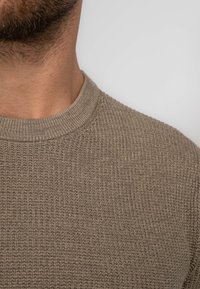 Khaki knit sweater featuring a textured pattern, ribbed neckline, and a close-fitting design for a streamlined appearance.