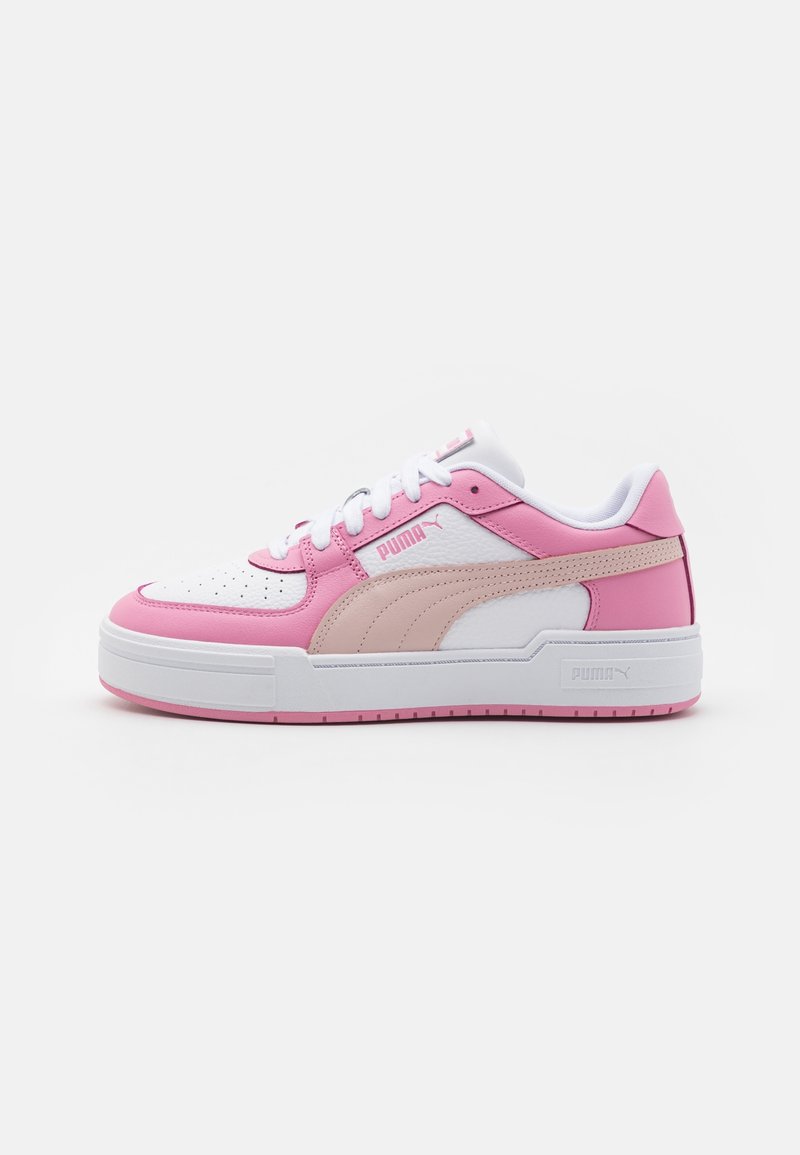 Vit och rosa sneaker med överdel i slät läder, perforeringar vid tårna, tjock sula och Puma-logotyp på sidan och tungan.