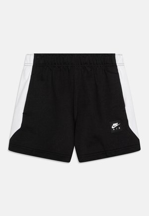 Calções pretos com painéis laterais brancos, cintura elástica e um patch com o logótipo Nike Air na parte frontal esquerda. Feitos de um tecido suave e respirável.