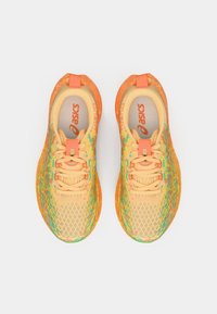 Lekkoatletyczne buty do biegania w pomarańczowym i żółtym kolorze z teksturowaną siateczkową cholewką, kontrastującymi zielonymi akcentami oraz amortyzowaną podeszwą.