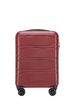 Red hard-shell suitcase with a textured surface, horizontal ridges, black wheels, and a top handle for easy transport.