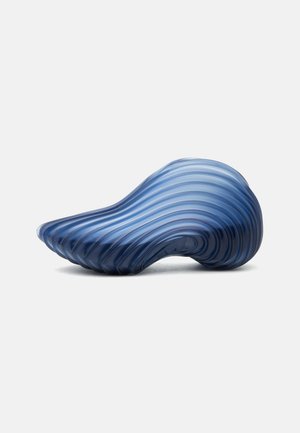 Objet lisse, bleu, à texture ondulée, en forme de coquille ou gousse abstraite reposant sur une surface blanche.