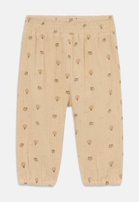 Pantalon en coton beige clair avec une taille élastique, présentant un motif ludique de montgolfières et de petits animaux. 