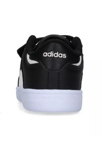 Sneakers Adidas neri con tomaia sintetica liscia, logo bianco sul retro e suola in gomma bianca a contrasto. Nessun motivo o accentuazione visibile.