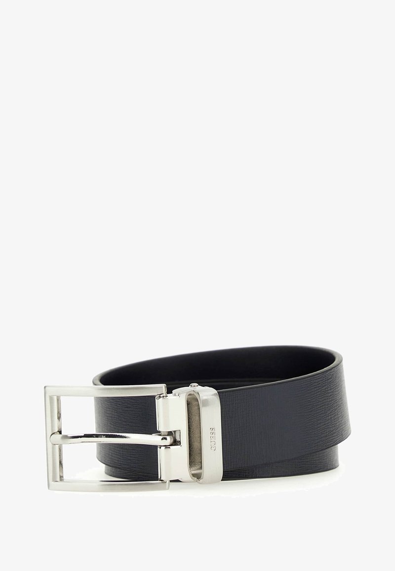Zwarte leren riem met een gestructureerde afwerking, voorzien van een zilveren rechthoekige gesp en een strak ontwerp. Verstelbare lengte, minimalistische stijl.