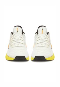 Balti sportiniai bateliai su kvėpuojančiu tinklu, geltonu guminio pado apvalkalu, juodais akcentais ir oranžiniu logotipu. Yra plokščios raišteliai ir paminkštinta liežuvėlis.