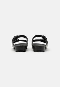 Schwarze Sandalen mit zwei Riemen und einem strukturierten Fußbett. Verfügen über verstellbare Schnallen, eine robuste Sohle mit Grip und ein schlichtes Design.
