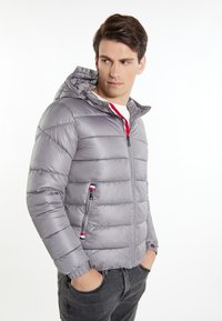 Giubbotto imbottito grigio con cappuccio, design trapuntato, zip frontale e polsini elasticizzati. Presenta accenti di colore sulle zip.