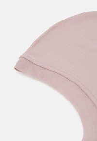 Tessuto rosa chiaro, texture liscia, design aderente con scollatura rotonda e bordo piegato, che sottolinea morbidezza e elasticità.