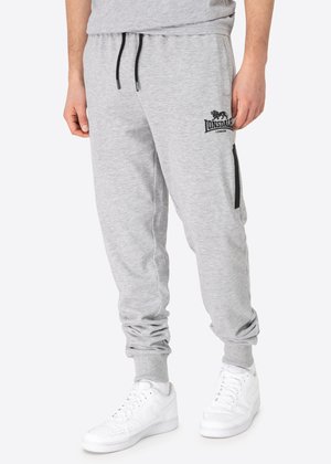 Grey fleece joggers with an elastic waistband, drawstring, and side zip pockets; features a black logo on the upper left side.