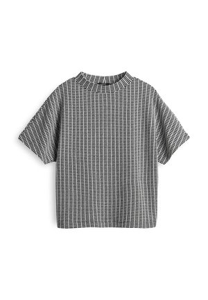 Camicia a maniche corte bianca e nera con collo alto, caratterizzata da un motivo a griglia testurizzato, realizzata in tessuto morbido con una vestibilità comoda.