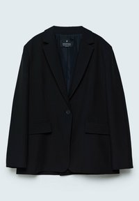 Blazer noir à un seul bouton avec revers à cran et poches à rabat, présenté sur un fond clair uni.