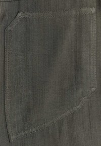Gros plan d'une poche en tissu gris foncé avec des coutures visibles et un motif de tissage texturé.
