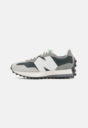 Szaro-czarny niski sneaker z białym logo "N", białymi sznurowadłami i fakturowaną czarną podeszwą, widziany z boku na białym tle.
